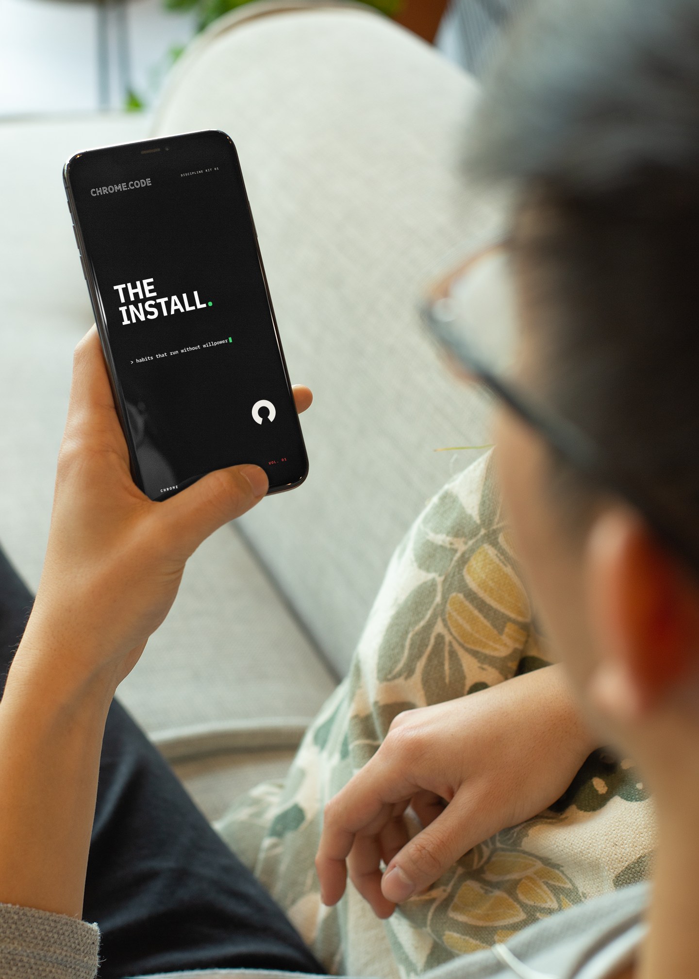 A man reading THE INSTALL on his phone